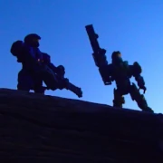 Two space soldier outdoors figures holding large weapons, sky is sunset dark blue