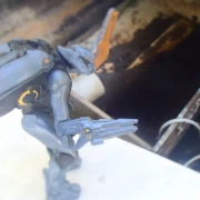 Armored alien on rim of small broken down boat cavity facing away