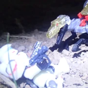A robotic velociraptor bears its jaws towards a space soldier in a sleek helmet on their back with two pistols in each hand.