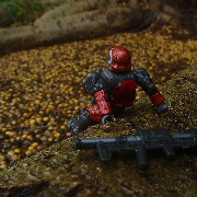 Armored space soldier sitting on a tree root overlooking a pond filled with yellow and brown seed pods on a rainy day.