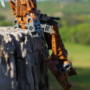 Close shot of a brown Bionicle's legs dangling off a wooden fenceposts with its arms at its side.